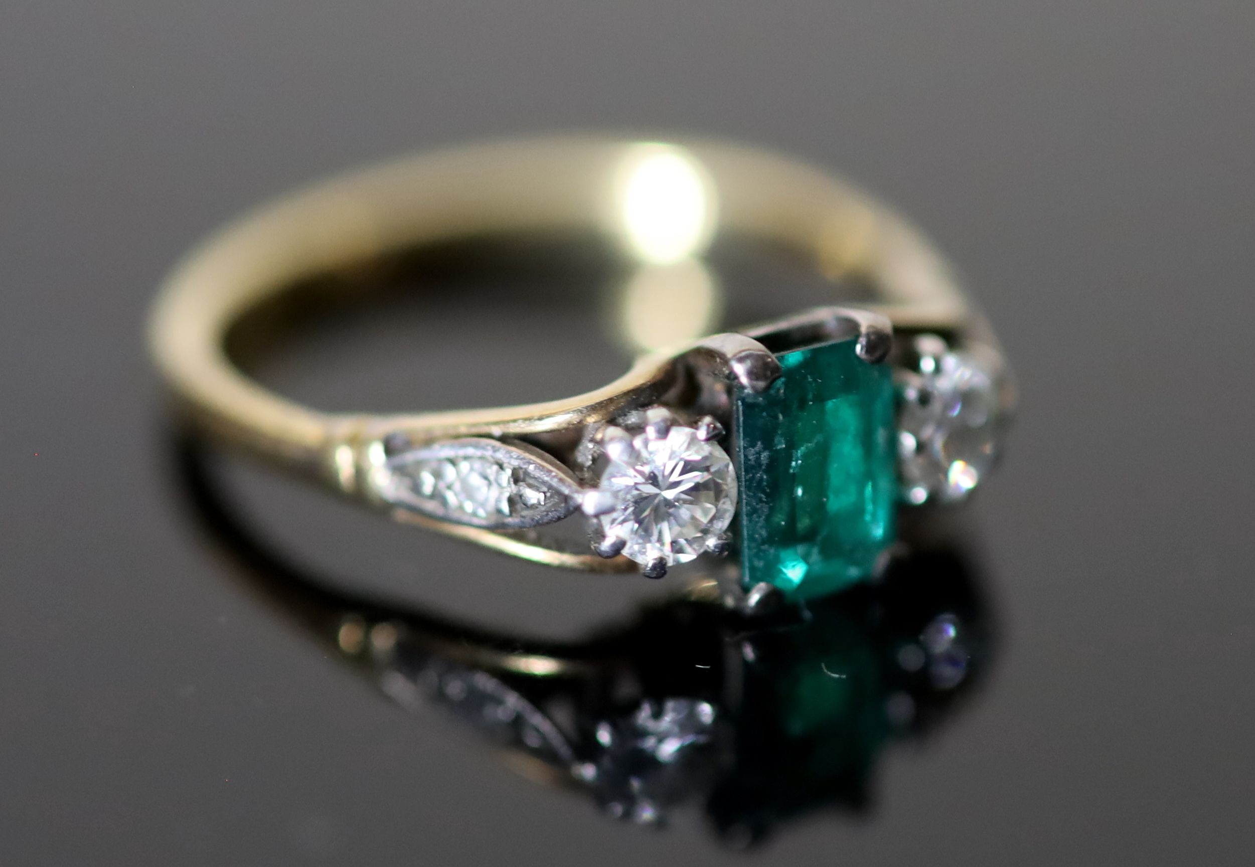 An 18ct gold, emerald and diamond set three stone ring,